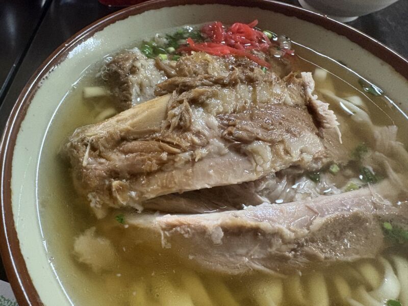 Image for the Tweet beginning: 【今回の沖縄での昼飯は「なかむら屋」さんのソーキソバ】
浦添市にある古民家風のそば屋です。
本ソーキソバが有名で、豚骨＋かつお出汁の透明感のあるあっさり系ながらコクがある味わい。秘伝のたれでじっくり煮込まれています。麺は平麺と細麺から選べますが平麺を選択、美味です。
これから東京へ 